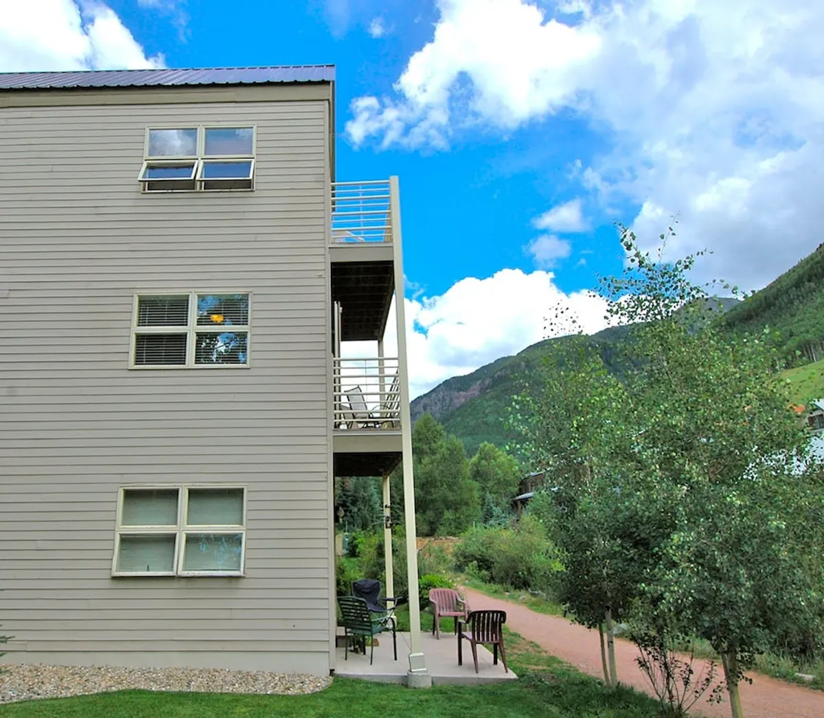 The image spotlights an inviting balcony with mountain views and comfortable outdoor seating, just steps from the living and dining spaces. The scene evokes the possibility of enjoying morning coffee or intimate meals while surrounded by nature.